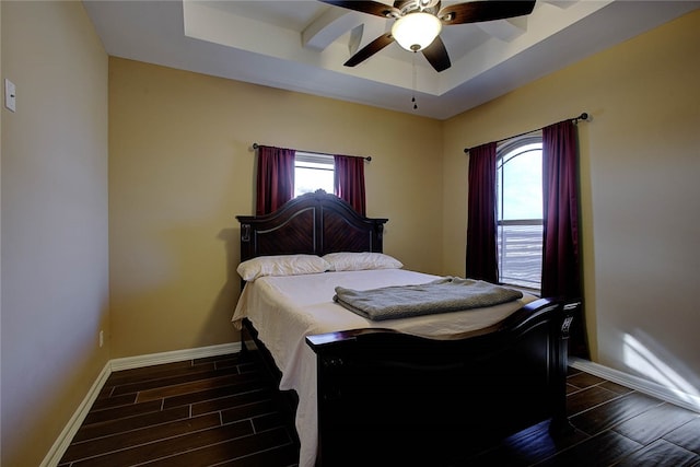 bedroom with a raised ceiling, ceiling fan, and dark hardwood / wood-style flooring