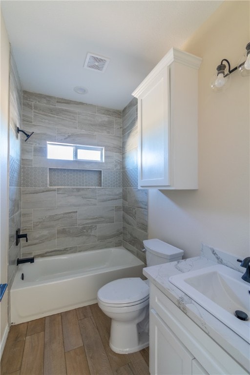 full bathroom featuring vanity, hardwood / wood-style flooring, toilet, and tiled shower / bath