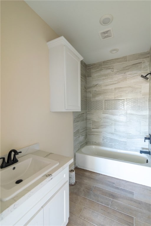 bathroom featuring vanity and tiled shower / bath