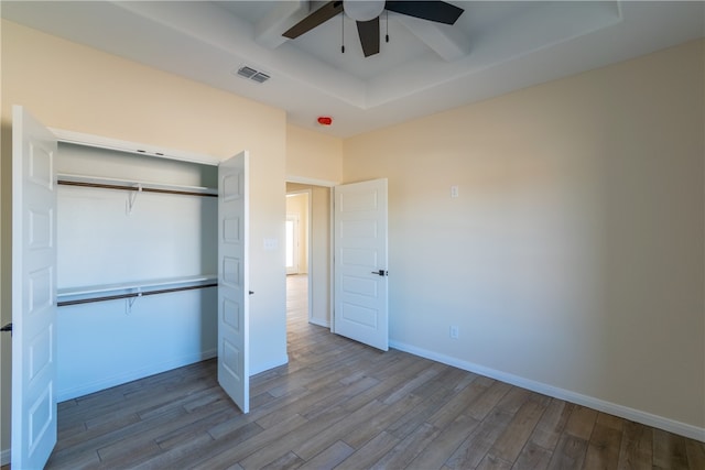 unfurnished bedroom with wood-type flooring, a closet, and ceiling fan