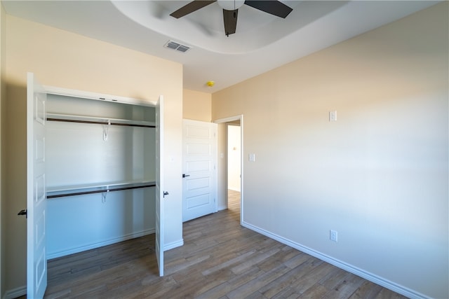 unfurnished bedroom with a closet, hardwood / wood-style flooring, and ceiling fan