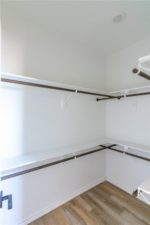 walk in closet with light hardwood / wood-style floors