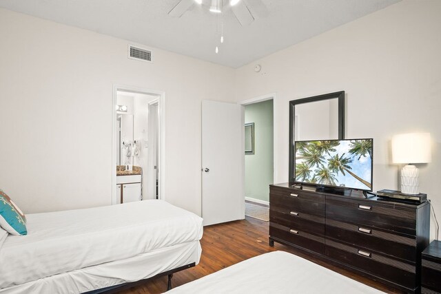 bedroom with ensuite bath, ceiling fan, and dark hardwood / wood-style floors