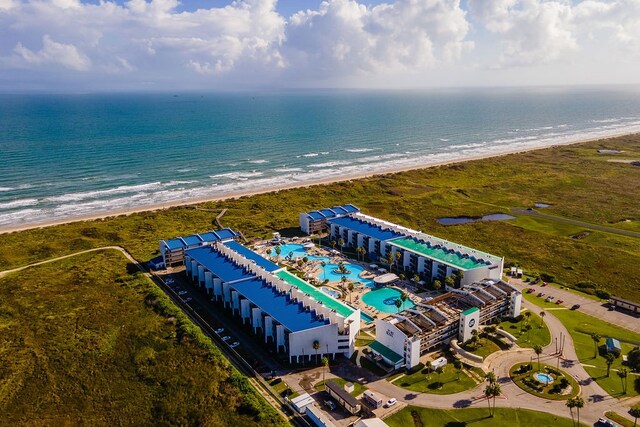 birds eye view of property with a water view and a beach view