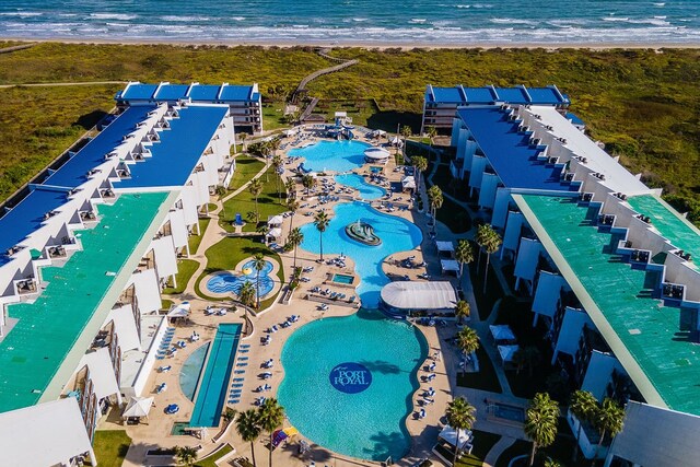 birds eye view of property with a water view and a beach view