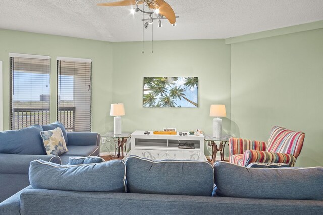 living room with a textured ceiling and ceiling fan