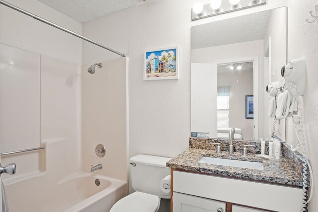 full bathroom with vanity, a textured ceiling, toilet, and shower / bathtub combination