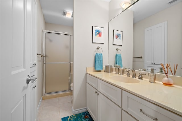 bathroom featuring tile patterned flooring, vanity, and a shower with shower door