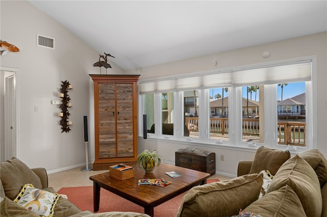 carpeted living room with a wealth of natural light and vaulted ceiling