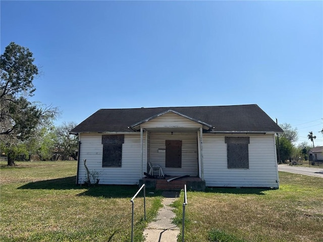bungalow-style home with covered porch and a front yard