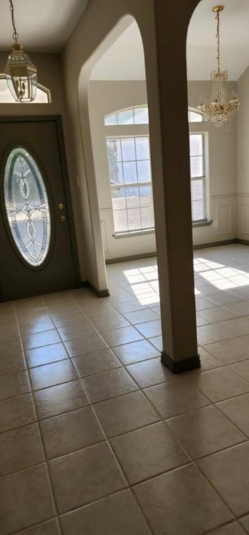 409 Fairway Oaks St, Rockport, TX 78382 - entrance foyer with arched walkways, an inviting chandelier, and a healthy amount of sunlight