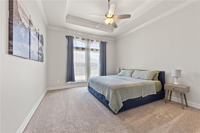 bedroom featuring carpet flooring, a raised ceiling, ornamental molding, baseboards, and a ceiling fan