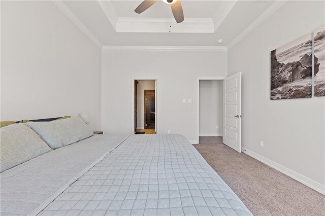 unfurnished bedroom featuring a raised ceiling, carpet floors, crown molding, baseboards, and ceiling fan