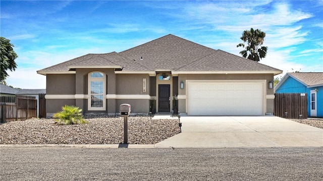 view of front facade featuring concrete driveway, an attached garage, stucco siding, and fence