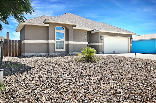 view of front of home featuring a garage, stucco siding, fence, and driveway