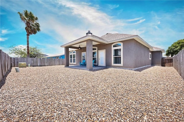 back of property featuring a patio area, a ceiling fan, stucco siding, and a fenced backyard