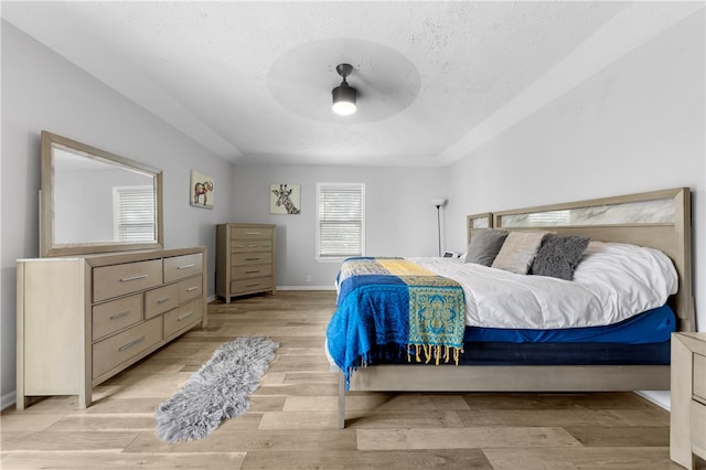 bedroom with light hardwood / wood-style flooring and a textured ceiling