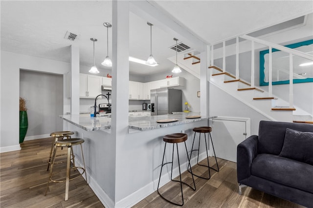 kitchen featuring kitchen peninsula, stainless steel refrigerator with ice dispenser, dark hardwood / wood-style floors, a breakfast bar area, and white cabinets