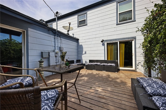 wooden terrace with an outdoor living space