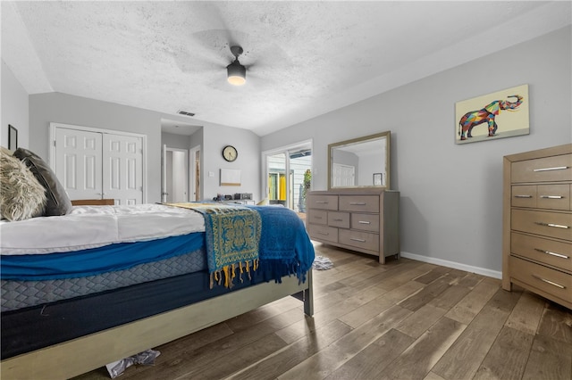 bedroom with a textured ceiling, dark wood-type flooring, ceiling fan, and a closet