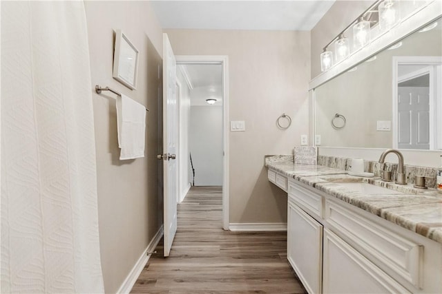 full bath with vanity, wood finished floors, and baseboards