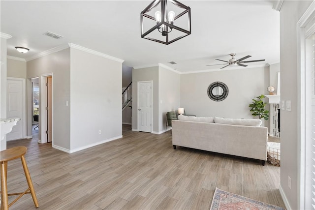 living area featuring light wood-type flooring, visible vents, ornamental molding, and stairs