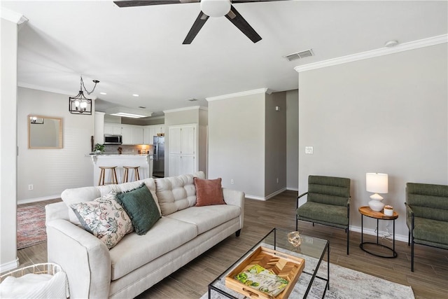 living room with crown molding, baseboards, and wood finished floors