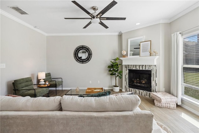 living area featuring visible vents, a healthy amount of sunlight, and ornamental molding