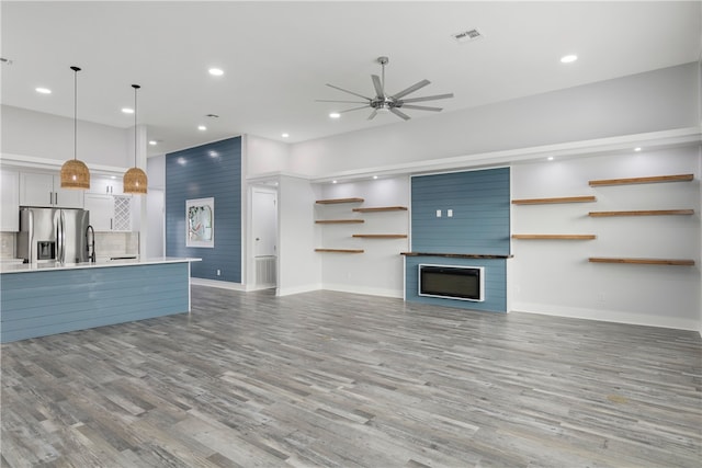 unfurnished living room with light hardwood / wood-style flooring and ceiling fan