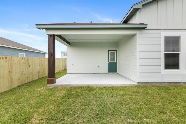 rear view of property featuring a yard and a patio area