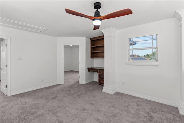 unfurnished bedroom with built in desk, ceiling fan, and light carpet