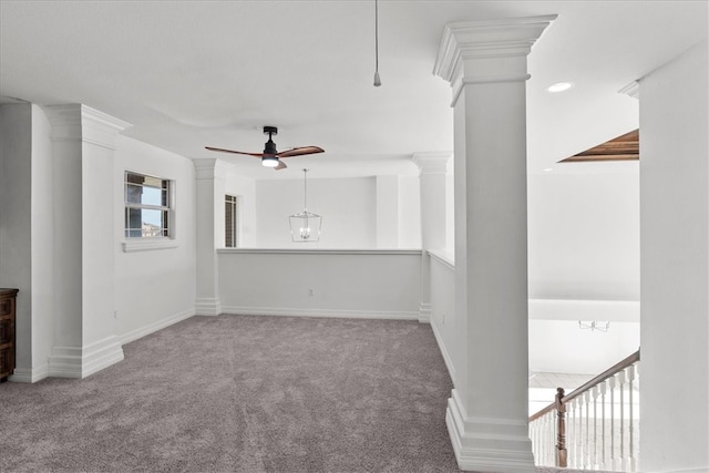 unfurnished living room featuring decorative columns, carpet flooring, and ceiling fan