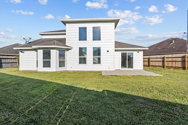 back of house featuring a lawn and a patio