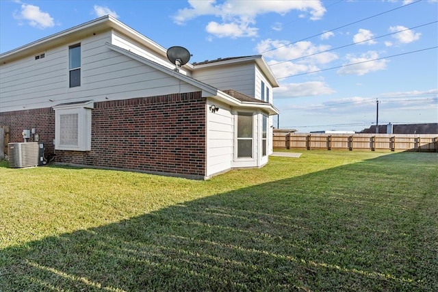 view of home's exterior featuring central air condition unit and a yard