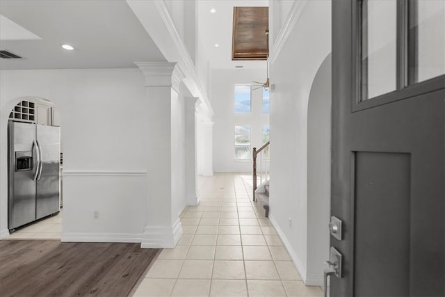 hall with ornate columns and light wood-type flooring