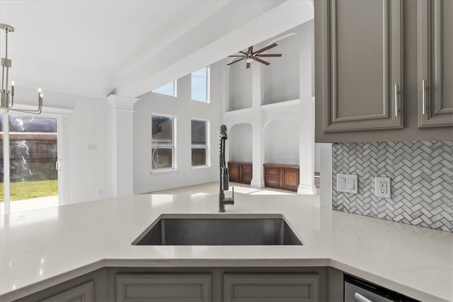 kitchen with gray cabinets, backsplash, pendant lighting, and sink