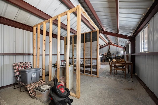 misc room featuring lofted ceiling and concrete flooring