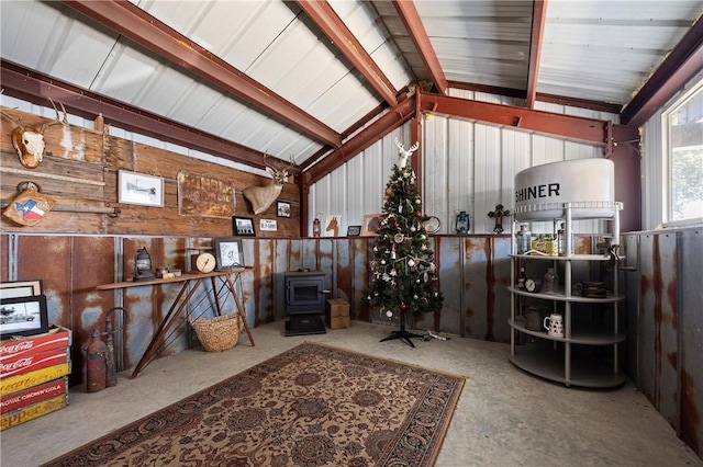 interior space featuring vaulted ceiling and a wood stove