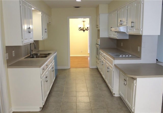 kitchen with white oven, sink, white cabinets, and black electric cooktop