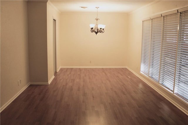 spare room with ornamental molding, dark hardwood / wood-style floors, and an inviting chandelier