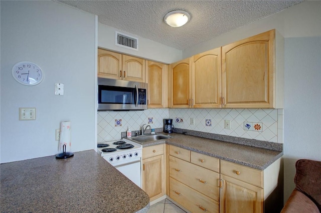 3938 Surfside Blvd Unit 2201, Corpus Christi, TX 78402 - kitchen featuring stainless steel microwave, a sink, light brown cabinetry, electric stove, and dark countertops