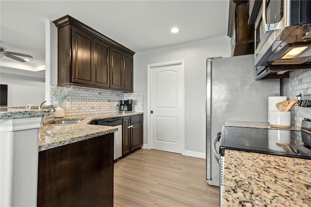 7209 Lake Tranquility Dr, Corpus Christi, TX 78414 - kitchen featuring stainless steel appliances, dark brown cabinets, decorative backsplash, light stone counters, and ceiling fan
