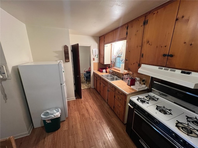 kitchen featuring ventilation hood, white appliances, sink, and light hardwood / wood-style floors