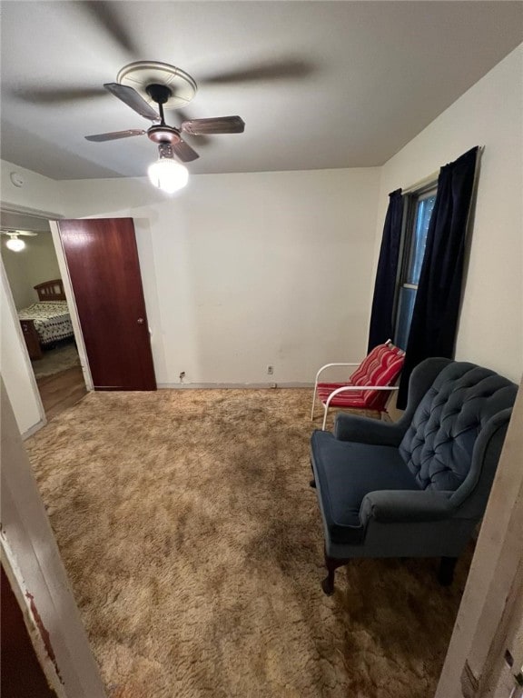 living area featuring ceiling fan and carpet floors