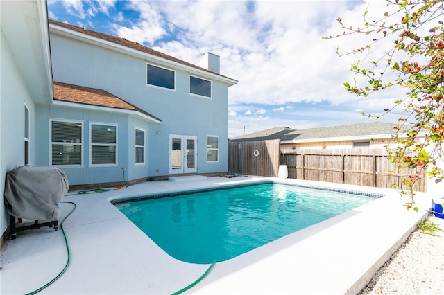 view of pool with a grill, a patio area, and french doors