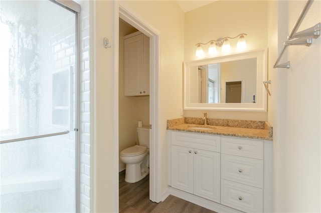 bathroom with walk in shower, hardwood / wood-style floors, vanity, and toilet