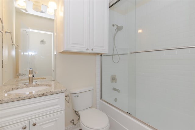 full bathroom with shower / bath combination with glass door, vanity, and toilet