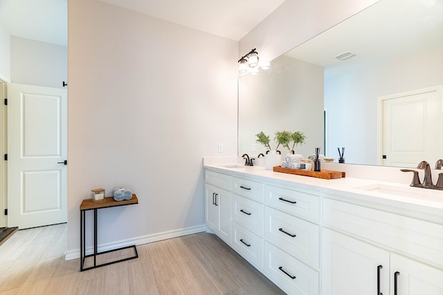 bathroom featuring double vanity, baseboards, visible vents, and a sink