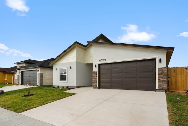 view of front of property featuring a garage, a front yard, stone siding, and stucco siding