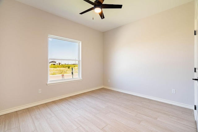 spare room with light wood-type flooring and baseboards